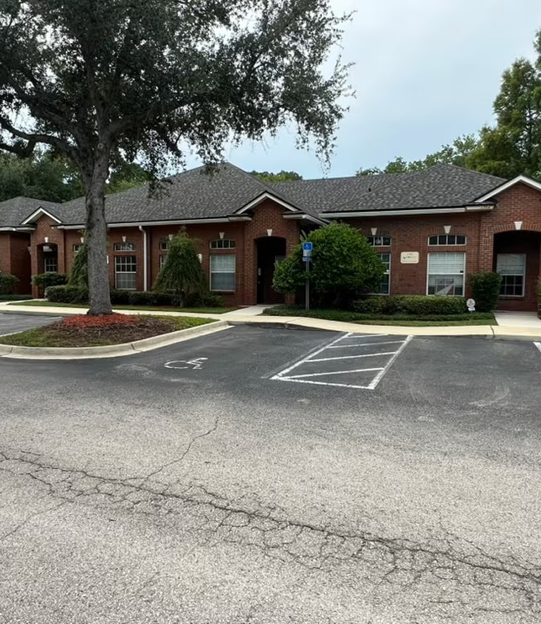 A one-story brick office building with a parking lot.