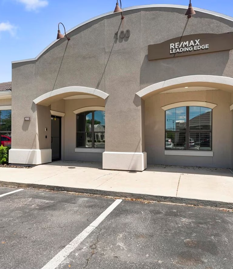 RE/MAX Leading Edge office building with parking lot.