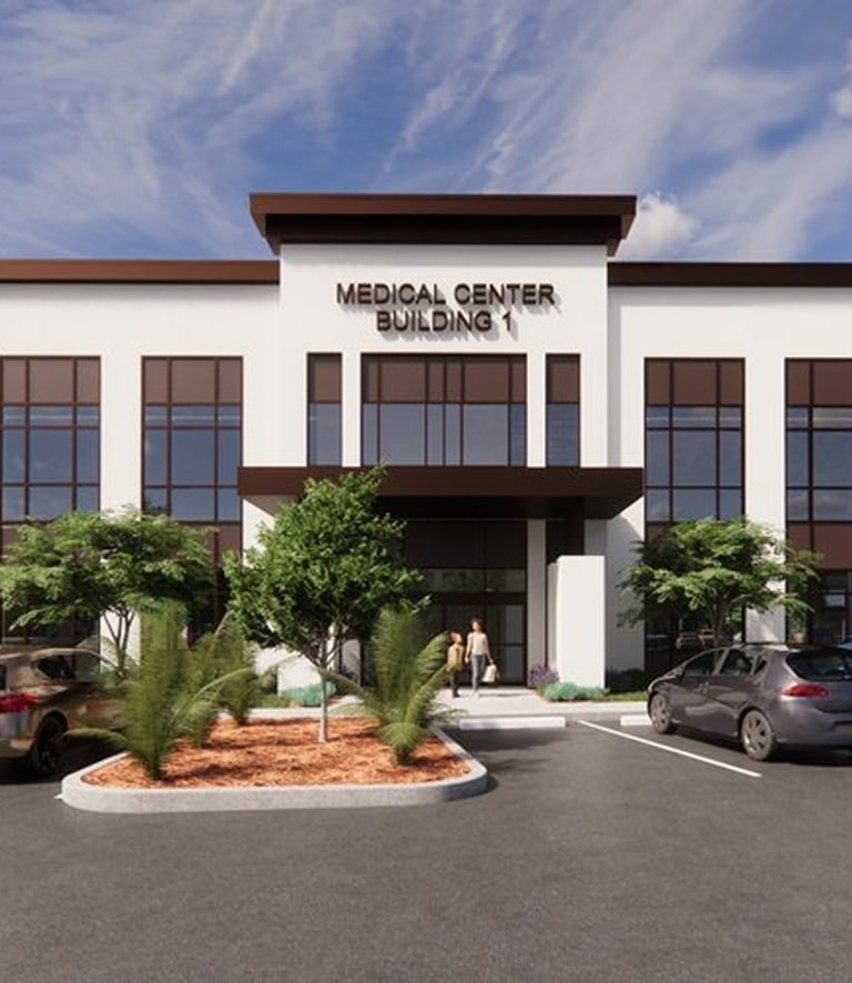 Modern medical center building with parking lot and landscaping.