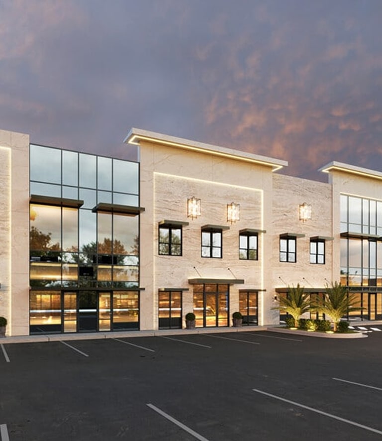 Modern two-story building with large windows and a parking lot.